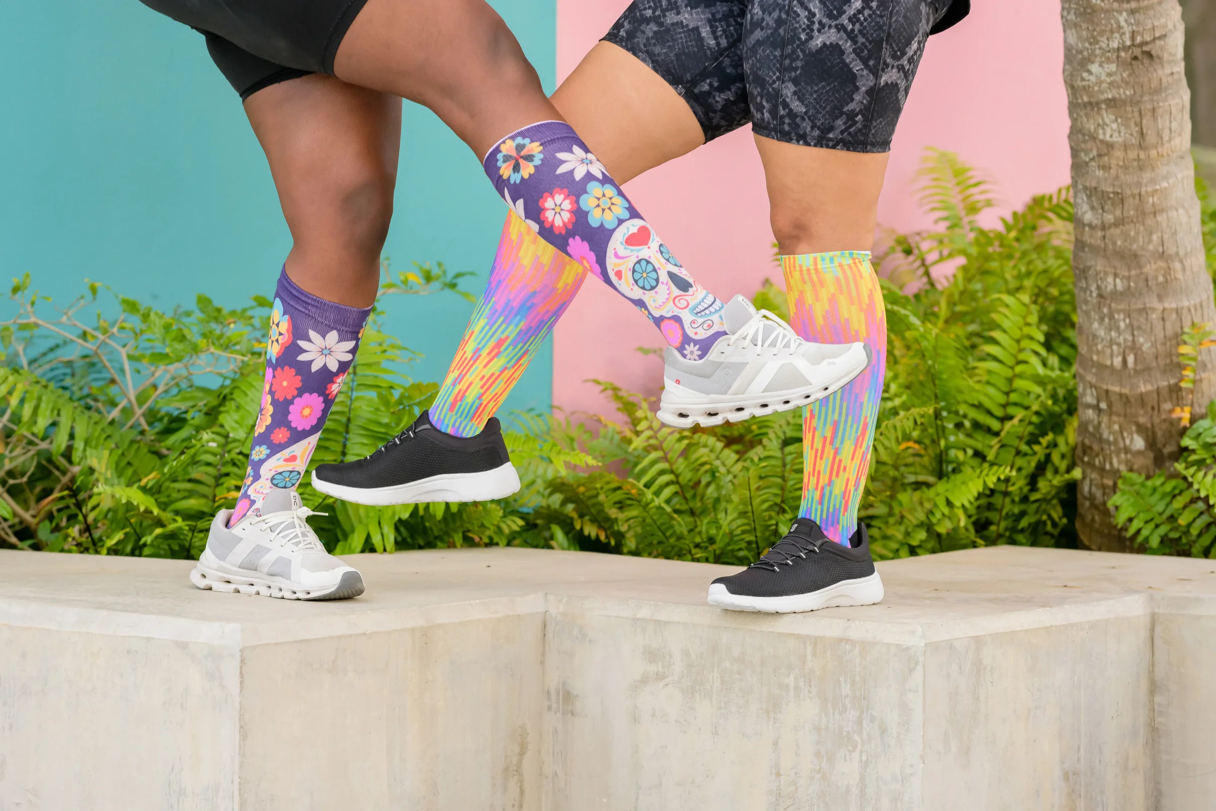 Two people stepping up a ledge in bright patterned socks and sneakers